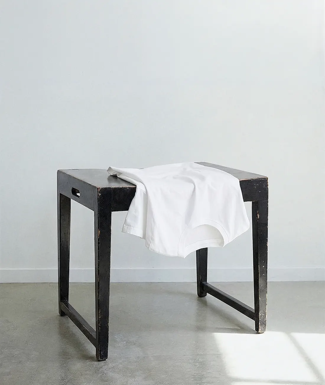 White blank t-shirt on a wooden stool